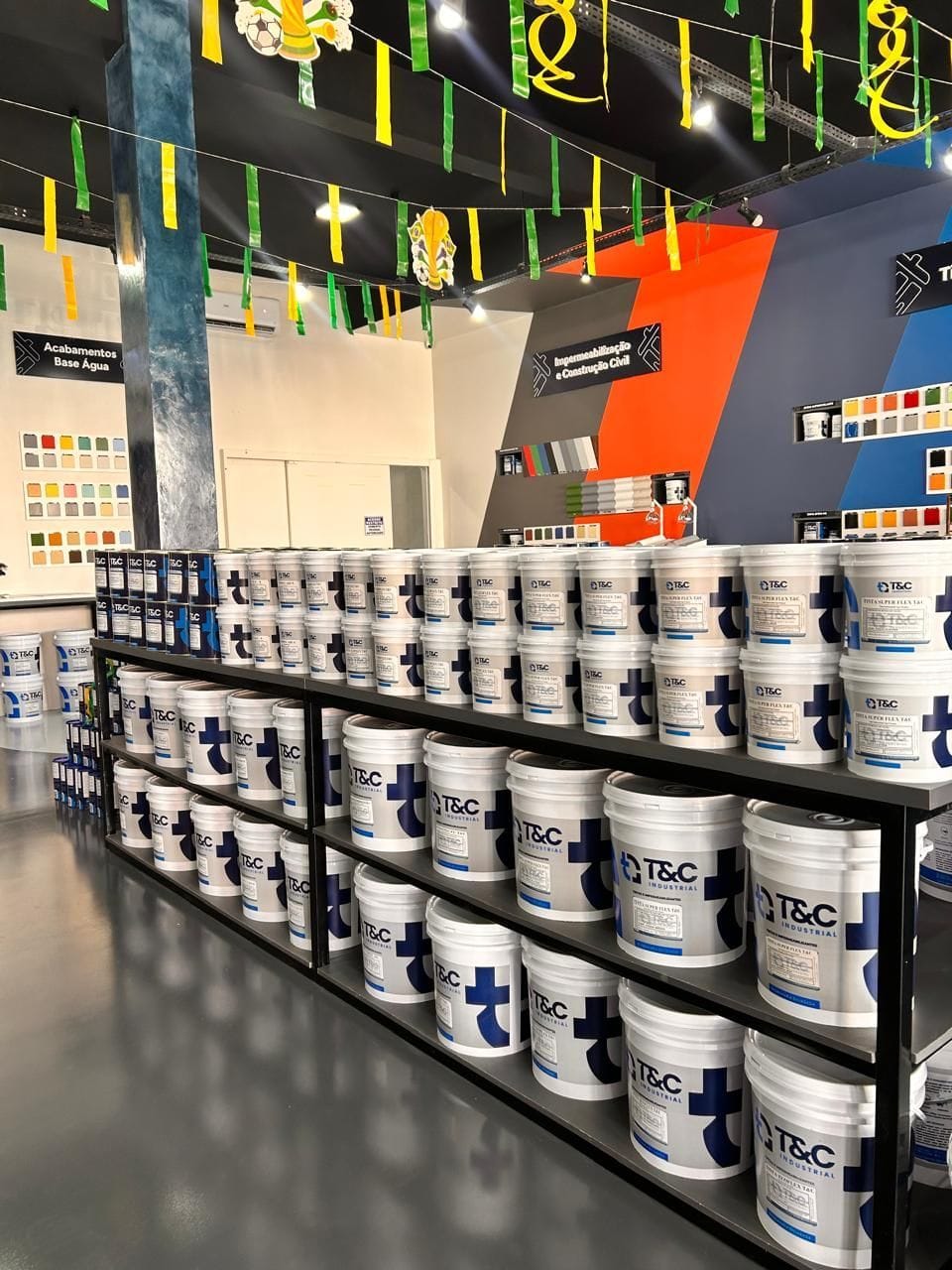 Interior da loja Impercolor com as prateleiras de baldes e galões da T&C Industrial