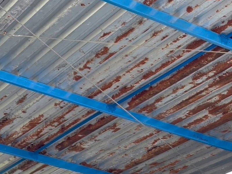 Telhas metálicas tomadas pela ferrugem, vistas por baixo da cobertura